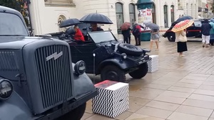 Symboliczna ekspozycja: niemieckie auta z okresu nazizmu, a za nimi KOD