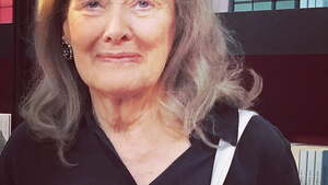 Noblistka przeciwko francuskiej policji. W tle zamieszki